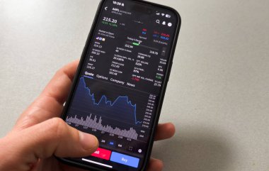 Kyiv, Ukrayna - 20 Mart 2025: Apple borsa uygulamasında yükselen yeşil hisse fiyatlarını gösteriyor. Arka planda, yüksek kaliteli fotoğraf