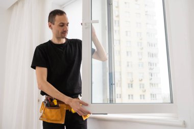 Genç tamirci gündüz odasındaki pencere çerçevesini tamir ediyor. Yüksek kalite fotoğraf