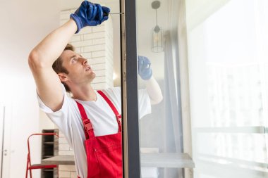 İnşaat işçisi eve pencere kuruyor