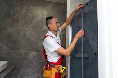 İçerideki plastik pencereyi ölçen bir işçi. Kurulum süreci. Yüksek kalite fotoğraf