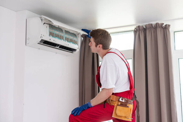 Service man is cleaning, repair and maintenance of air conditioner.