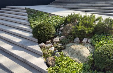 Göz kamaştırıcı bir merdiven zarif bir şekilde yükselir, sıcak güneş ışığıyla güzelce aydınlatılır ve canlı yeşilliklerle çevrilidir. Yüksek kalite fotoğraf