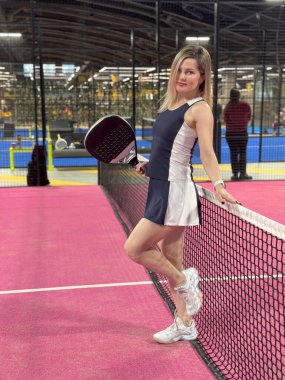 Pembe raket tenis kortunda Padel oynayan genç bir kadın. Yüksek kalite fotoğraf