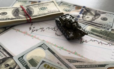 Dolar banknotlarının arka planında oyuncak tankı var. Yüksek kalite fotoğraf