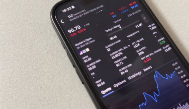 Kyiv, Ukrayna - 20 Mart 2025: Apple borsa uygulamasında yükselen yeşil hisse fiyatlarını gösteriyor. Arka planda, yüksek kaliteli fotoğraf