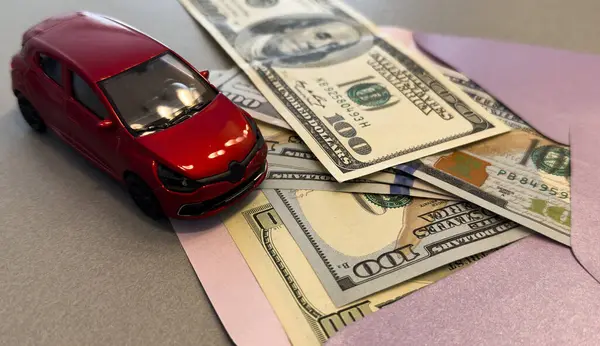 Üzerinde dolar banknotları olan bir zarf ve beyaz bir araba, ulaşım maliyeti planlama konsepti. Yüksek kalite fotoğraf