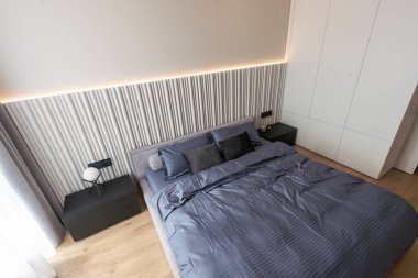 Modern bir evin büyük penceresinin yanında büyük bir yatağı olan küçük bir yatak odası. Yüksek kalite fotoğraf