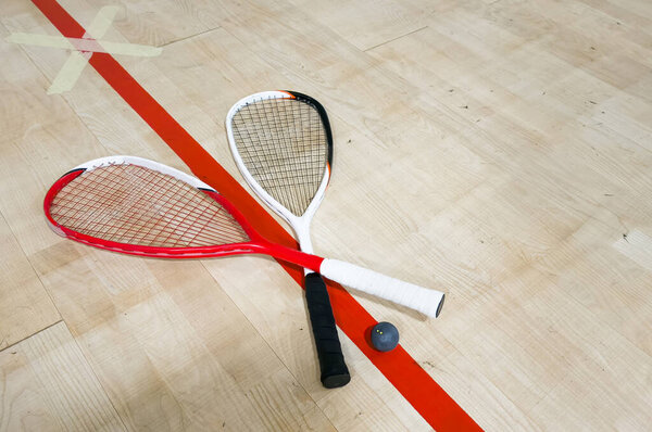 Squash rackets and ball on court floor, top view. High quality photo