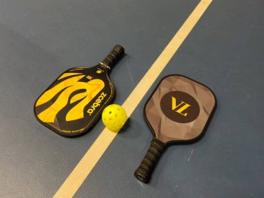 Kyiv, Ukrayna - 14 Aralık 2024 Pickleball tenis raketi sahada. Kopyalama alanı olan mavi arkaplan. Spor sahası ve top. Yüksek kalite fotoğraf