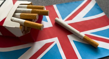 Kül tablasında yanan sigara siyah arka planda izole edilmiş İngiliz bayrağı. Yüksek kalite fotoğraf