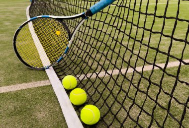 Tenis topu ve raket güneşli çimen tenis kortunun zemininde. Yaz, sağlıklı yaşam tarzı, spor ve hobiler. Yüksek kalite fotoğraf