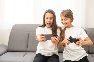 Evde video oyunu oynayan iki kız kardeş. Mutlu çocuk, tasasız çocukluk konsepti. Yüksek kalite fotoğraf