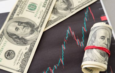 Finansal tablonun arka planında Amerikan doları var. Konsept Ekonomi, iş yatırımları, ekonomik kriz, kardaki düşüş, durgunluk. Karışık medya. Yüksek kalite fotoğraf
