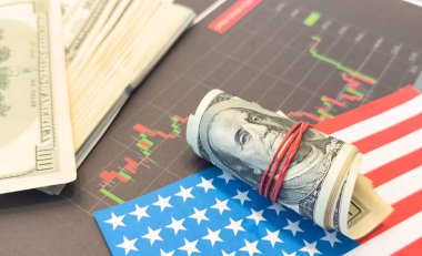 Finansal tablonun arka planında Amerikan doları var. Konsept Ekonomi, iş yatırımları, ekonomik kriz, kardaki düşüş, durgunluk. Karışık medya. Yüksek kalite fotoğraf