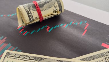 Finansal tablonun arka planında Amerikan doları var. Konsept Ekonomi, iş yatırımları, ekonomik kriz, kardaki düşüş, durgunluk. Karışık medya. Yüksek kalite fotoğraf
