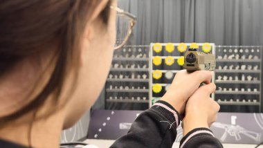 Kadın atış poligonunun dışındaki hedeflere nişan alıyor. Yüksek kalite fotoğraf