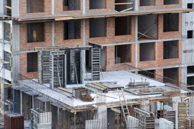 İnşaat işçileri çimento çerçevelerinin montajında işbirliği yapıyorlar. Yüksek kalite fotoğraf