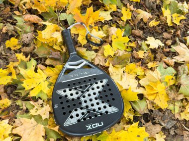 Ukrayna Kyiv, 22 Ekim 2024 padel raket nox ve sarı sonbahar yaprakları. Yüksek kalite fotoğraf