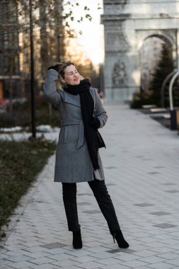 Paltolu kız güneşli bir günde şehirde dolaşır. Yüksek kalite fotoğraf