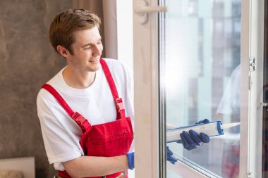 a repairman repairs, adjusts or installs metal-plastic windows in the apartment. glazing of balconies, loggias, verandas in house. production of double-glazed windows to individual sizes.