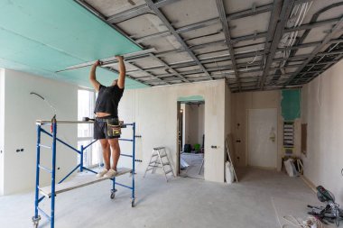 Adam alçı tavanlar için metal çerçeve monte ediyor. Yüksek kalite fotoğraf