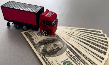 Beyaz oyuncak kamyonet dolarların üzerinde yatıyor, mesaj için yer var. Yüksek kalite fotoğraf