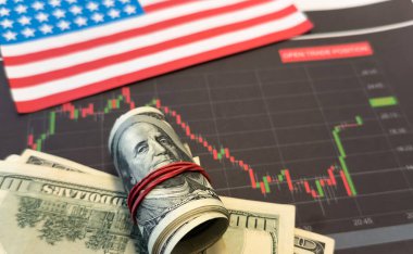 Finansal tablonun arka planında Amerikan doları var. Konsept Ekonomi, iş yatırımları, ekonomik kriz, kardaki düşüş, durgunluk. Karışık medya. Yüksek kalite fotoğraf