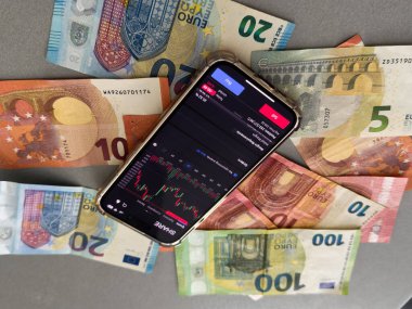 Mobil bankacılık ve finans kavramı: borsa uygulamalı akıllı telefon, avro banknotları. İş geçmişi. Bulanık konsept. Yüksek kalite fotoğraf