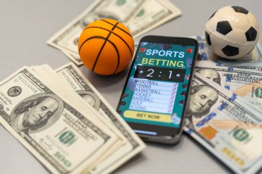Akıllı telefon, kumar, mobil uygulama ve yakın planlı basketbol topu. Spor ve bahis konsepti. Yüksek kalite fotoğraf