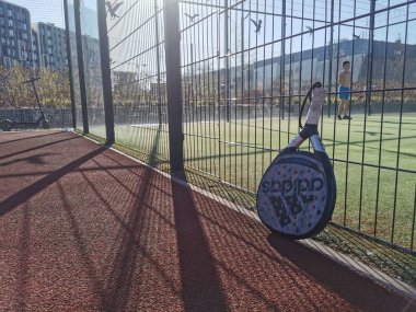 Ukrayna Kyiv, 11 Nisan 2024: Padel raketi adidas ve padel topu yeşil sahada. Yüksek kalite fotoğraf