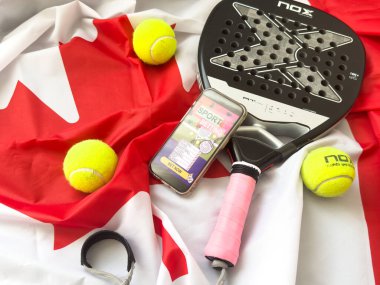 Kyiv, Ukrayna, 3 Eylül 2024 Kanada bayrağı, padel raket nox ve spor bahisleri ile akıllı telefon. Yüksek kalite fotoğraf