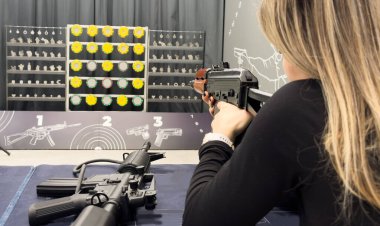 Genç bir kız silahla atış talimi yapıyor. Yüksek kalite fotoğraf