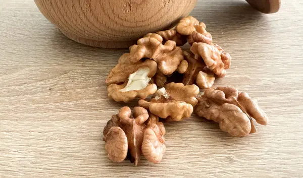 cevizler siyah bir masanın üzerine ahşap bir tabaktan dökülüyor. Yüksek kalite fotoğraf