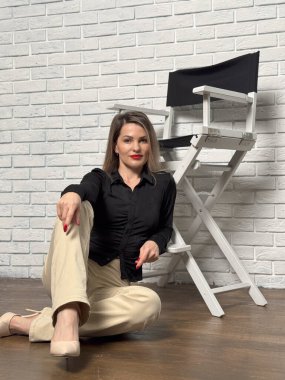 Sandalyede poz veren şık bir kadın. Stüdyo çekimi. - Evet. Yüksek kalite fotoğraf