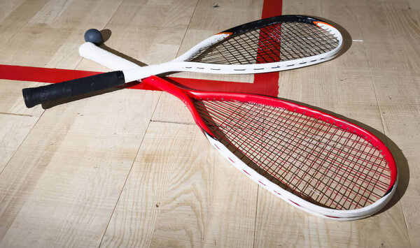 Squash Rackets And a Ball on a Wooden Court Floor. Sport Theme. High quality photo