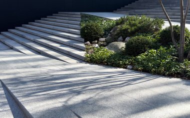 Göz kamaştırıcı bir merdiven zarif bir şekilde yükselir, sıcak güneş ışığıyla güzelce aydınlatılır ve canlı yeşilliklerle çevrilidir. Yüksek kalite fotoğraf