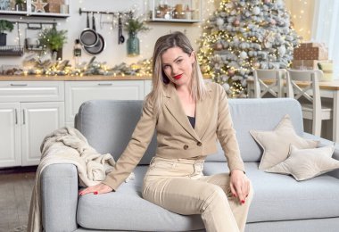 Noel süslemeli odada oturan güzel genç bir kadın. Yüksek kalite fotoğraf