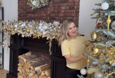 Lüks, eski bir Noel odası peri masalı iç dizaynı içinde, ışık, mum, fener ve çelenk ile süslenmiş, rahat, sihirli bir gecede güzel bir kadın. Yüksek kalite fotoğraf