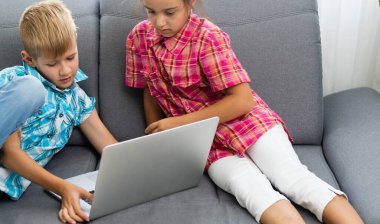  Çocuklar oturuyor ve dizüstü bilgisayar kullanıyor. Yüksek kalite fotoğraf