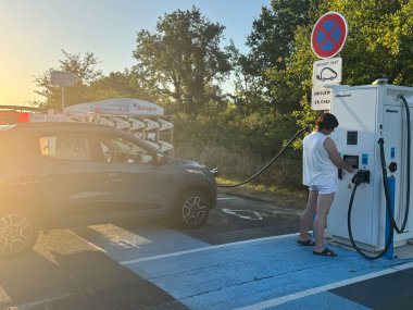 Mimizan, Fransa - 10 Temmuz 2025: Halka açık otoparkta elektrikli araçlar şarj ediliyor. Yüksek kalite fotoğraf