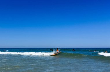 Okyanustaki sörfçüler sörf tahtasında. Köpük ve su sıçraması. Yüksek kalite fotoğraf
