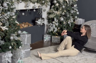 Neşeli, gülümseyen genç bir kadın evin sıcak bir iç odasında Noel tatili için hazırlanıyor. Yüksek kalite fotoğraf