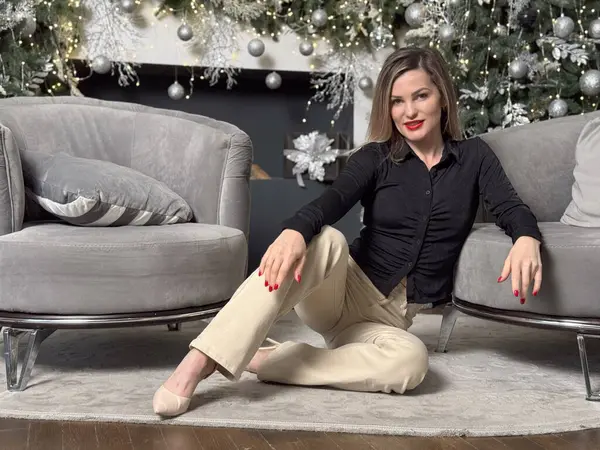 Güzel, genç bir kadın, Noel ağacıyla süslenmiş bir odada, evinde yeni yılı kutluyor. Yüksek kalite fotoğraf