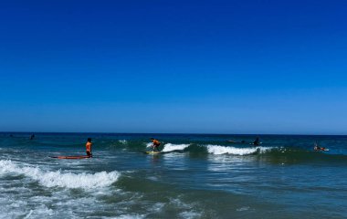 Okyanustaki sörfçüler sörf tahtasında. Köpük ve su sıçraması. Yüksek kalite fotoğraf