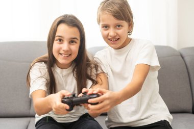 Oyun çubuklarıyla video oyunu oynayan iki küçük kız arkadaş. Heyecanlı ve odaklanmış Avrupalı çocuklar. Çocukluk konsepti. Eğlence ve rahatlık. Arkadaşlık fikri. Stüdyoda gri arka plan. Uzayı kopyala Yüksek kalite fotoğraf