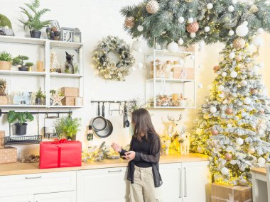 Süslü Noel odasında oturan sevimli küçük kız hediye kutusunu açıyor. Yüksek kalite fotoğraf