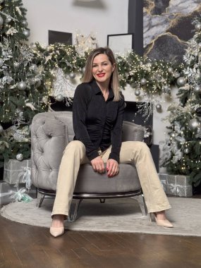 Neşeli, gülümseyen genç bir kadın evin sıcak bir iç odasında Noel tatili için hazırlanıyor. Yüksek kalite fotoğraf