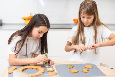  Çocuklar Noel kurabiyelerini birlikte süslüyor. Yüksek kalite fotoğraf