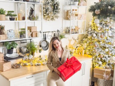 Neşeli, gülümseyen genç bir kadın evin sıcak bir iç odasında Noel tatili için hazırlanıyor. Yüksek kalite fotoğraf