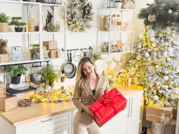 Neşeli, gülümseyen genç bir kadın evin sıcak bir iç odasında Noel tatili için hazırlanıyor. Yüksek kalite fotoğraf